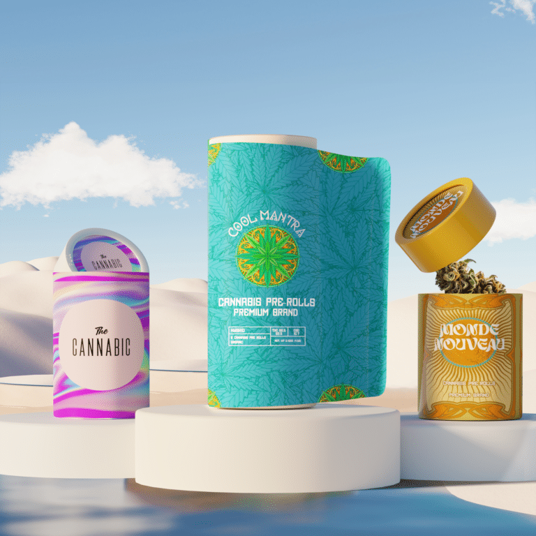 A display of three ATID eco-friendly, child-resistant cannabis packaging designs in a desert-inspired setting under a clear blue sky. The packaging includes a vibrant pink-and-purple cylindrical container labeled "The Cannabic," a tall teal package with cannabis leaf patterns labeled "Cool Mantra," and a yellow-orange cylindrical jar labeled "Monde Nouveau."