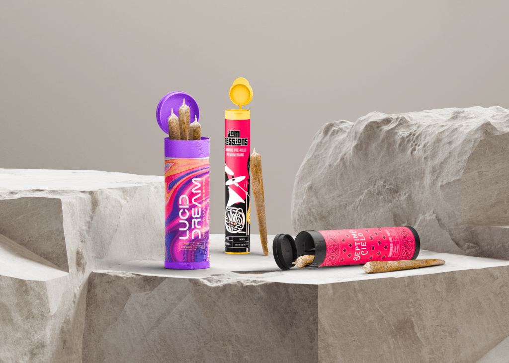 Three preroll tubes for two or three joints displayed on textured stone surfaces. The designs include a vibrant purple "Lucid Dream" tube, a bold red-and-black "Jam Sessions" tube, and a red "Septimo Cielo" tube, with prerolls partially revealed.